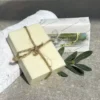 Tvål framför tvålförpackning med handduk i bakgrunden